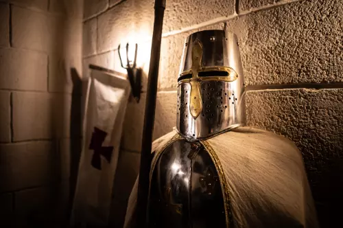 Un chevalier en armure à côté d'un étendard templier